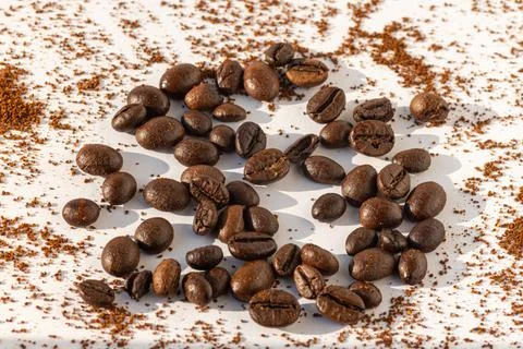 Brown roasted coffee beans on a background of ground coffee on a white backgr Stock Illustration