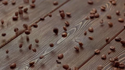 Brown roasted coffee beans drop on wooden board surface Stock Footage 242268537