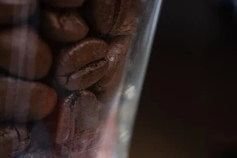 Brown roasted coffee beans inside a glass jar Foto stock