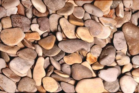 Brown rounded stones of heterogeneous structure, background Stock Photos