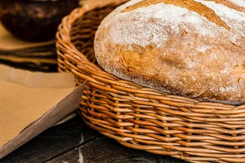 Brown rustic bread in a basket wicker wooden close-up on a table design base Stock Photos