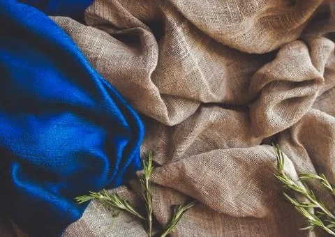 Brown rustic raw sackcloth, blue fabric and fresh green Italian rosemary herb Stock Photos