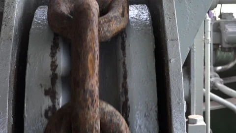Brown rusty anchor chain moves down on special support Stock Footage 113454796