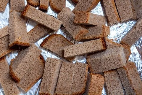 Brown rye bread slices on silver foil background for baking or drying Foto stock