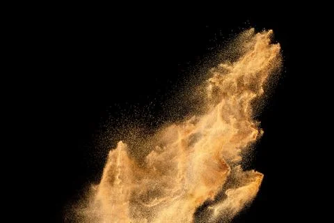 Brown sand explosion isolated on black background. Freeze motion of sandy d.. Stock Photos