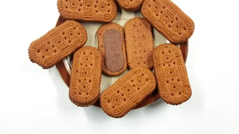 Brown sandwich biscuits rotating on a plate, revealing chocolate filling video Stock Footage 330722398
