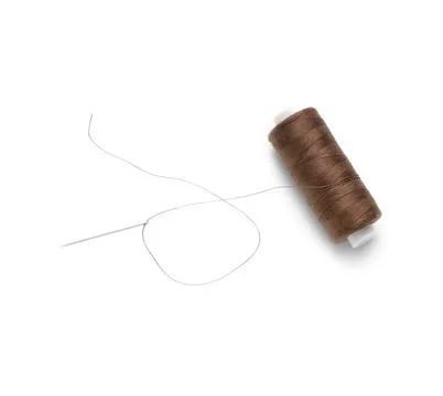 Brown sewing thread spool and needle isolated on white background, closeup Stock Photos