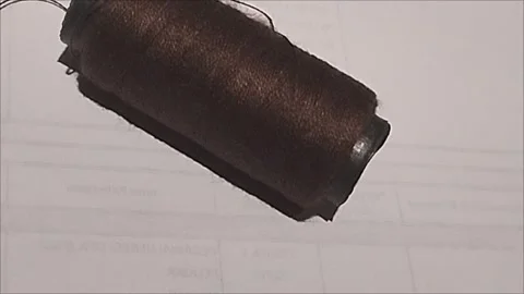 Brown Sewing Thread Spool Lying on White Background Stock Footage 296978472