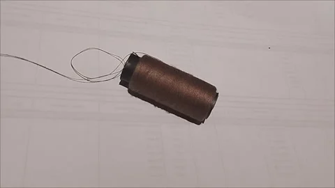 Brown Sewing Thread Spool Lying on White Background Stock Footage 296978594