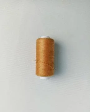 Brown sewing thread on a white background Foto stock
