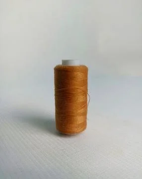 Brown sewing thread on a white background Foto stock