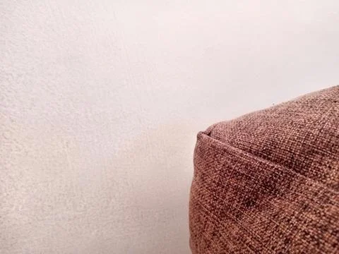 Brown Sofa Pillow Texture on Neutral Wall Stock Photos