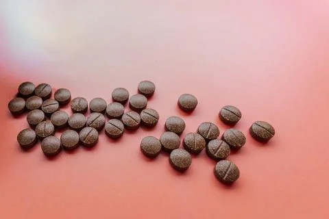 Brown speckled tablets arranged in the shape of an arrow. Stock Photos