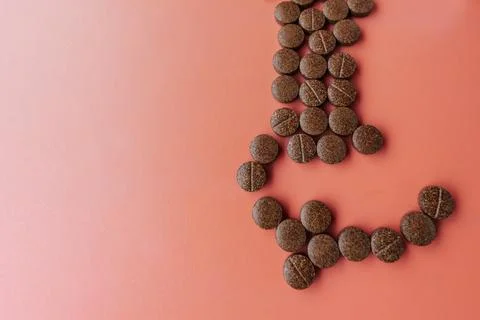 Brown speckled tablets arranged in the shape of an arrow. Stock Photos