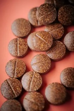 Brown speckled tablets arranged in the shape of an arrow. Stock Photos