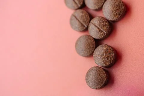 Brown speckled tablets arranged in the shape of an arrow. Stock Photos