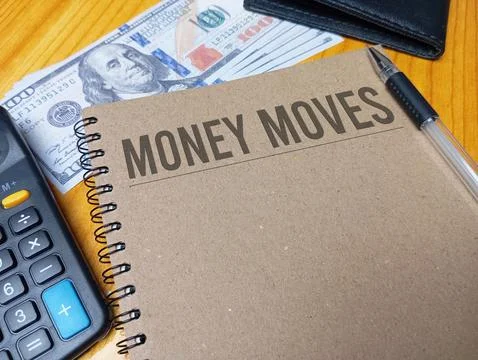Brown spiral notebook with MONEY MOVES text on a wooden desk with a calcula.. Stock Photos