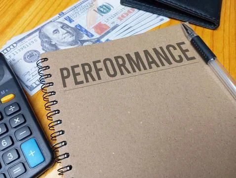 Brown spiral notebook with PERFORMANCE text on a wooden desk with a calcula.. Stock Photos