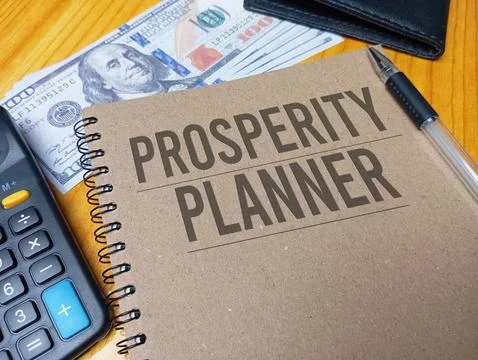 Brown spiral notebook with Prosperity Planner text on a wooden desk with a .. Stock Photos