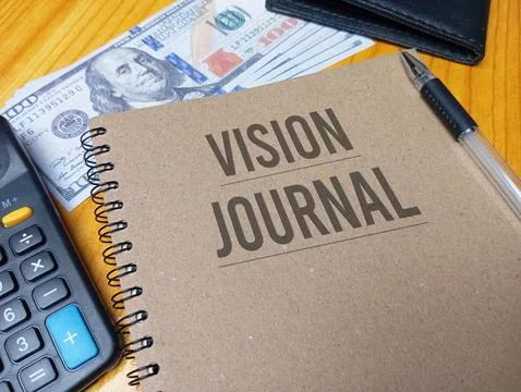 Brown spiral notebook with Vision Journal text on a wooden desk with a calc.. Stock Photos
