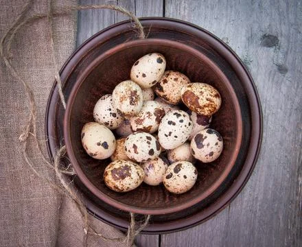 Brown spotted quail eggs in ceramic bowl Stockfoto's