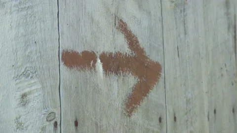 Brown spray paint arrow on old wooden wall / Hand held Stock Footage 130884547