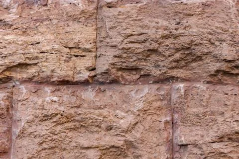 Brown stone wall large blocks tough weathered background base uneven base Stock Photos