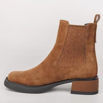 A brown suede ankle boot with a block heel is shown on a plain background, .. Stockfoto's