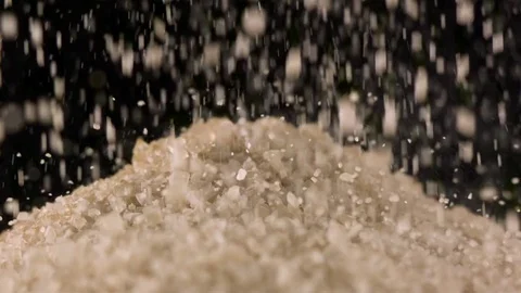 Brown sugar crystals falling in slow motion Видео 71212624