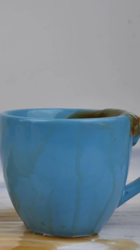 A brown sugar cube falling into a cup of black tea in slow motion Stock Footage 307811336