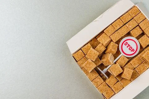 Brown sugar cubes in a box with a stop sign on display Stock Photos