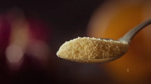 Brown sugar falling from a spoon Stock Footage 135015485