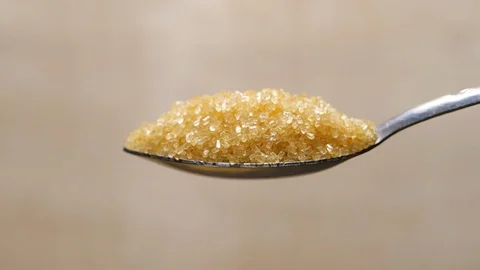 Brown sugar falling from tea spoon in slow motion Vídeo Stock 115141859