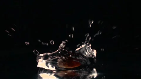 Brown sugar falling into water against black background. Super slow motion shot Vidéo 61109997