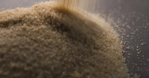 Brown sugar pouring slow motion in studio 4K pro res Video stock 273636107