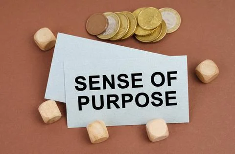 On a brown surface are coins, cubes and a business card with the inscription  Foto stock