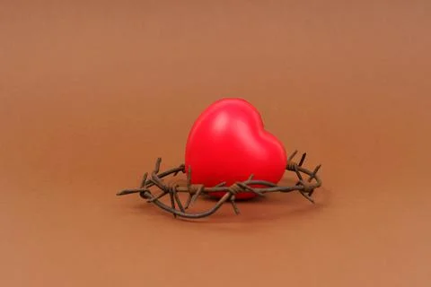 On the brown surface is a red heart, which is surrounded by barbed wire. Stockfoto's