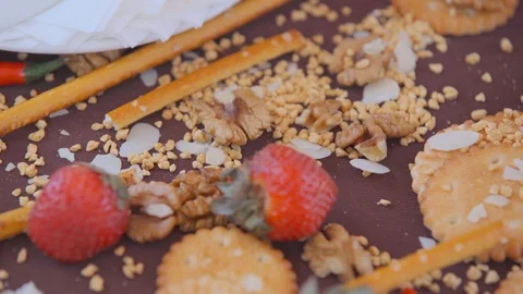 On the brown tablecloth are scattered walnuts, cookies, strawberries 스톡 동영상 103395543