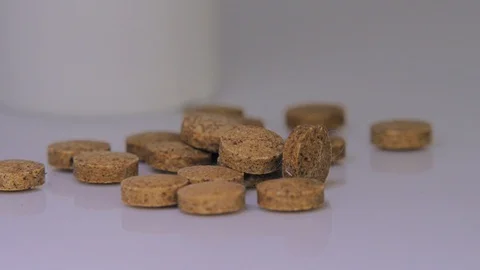 Brown tablets in ray of light Stock Footage 129607015