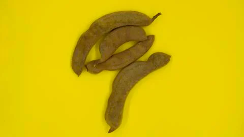 Brown tamarind pod on a yellow background Stock Photos