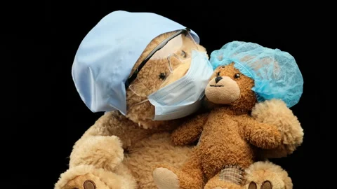 Brown teddy bear sits in protective plastic glasses, a medical disposable mask a Stock Footage 147549938