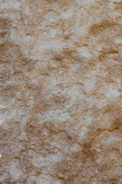 Brown textured stone wall surface illuminated by natural daylight showing r.. Stock Photos