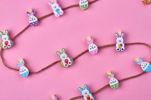 Brown thread and decorative easter rabbits on pink background. Stock Photos