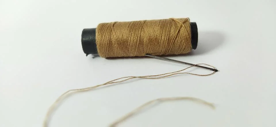 Brown thread with a needle Stock Photos