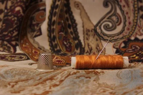 Brown Thread With Thimble and Scissors on Vintage Fabric Stock Photos