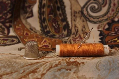 Brown Thread With Thimble and Scissors on Vintage Fabric Stock Photos