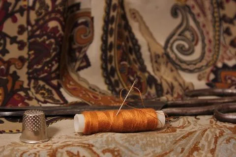 Brown Thread With Thimble and Scissors on Vintage Fabric Stock Photos