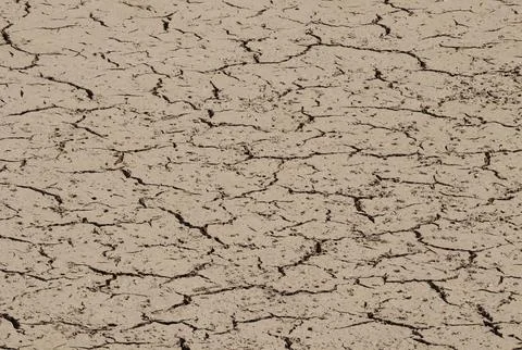 A brown torn soil due to drought. cracks in dry ground. drought, cracked ground. Stock Photos