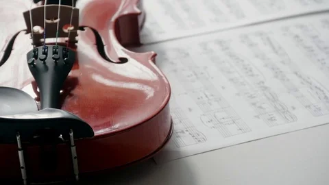 Brown violin with musical notes on a white background (spinning and panning Stock Footage 73893186
