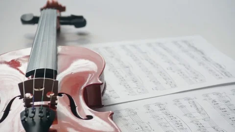 Brown violin with musical notes on a white background (spinning and panning Stock Footage 73893241